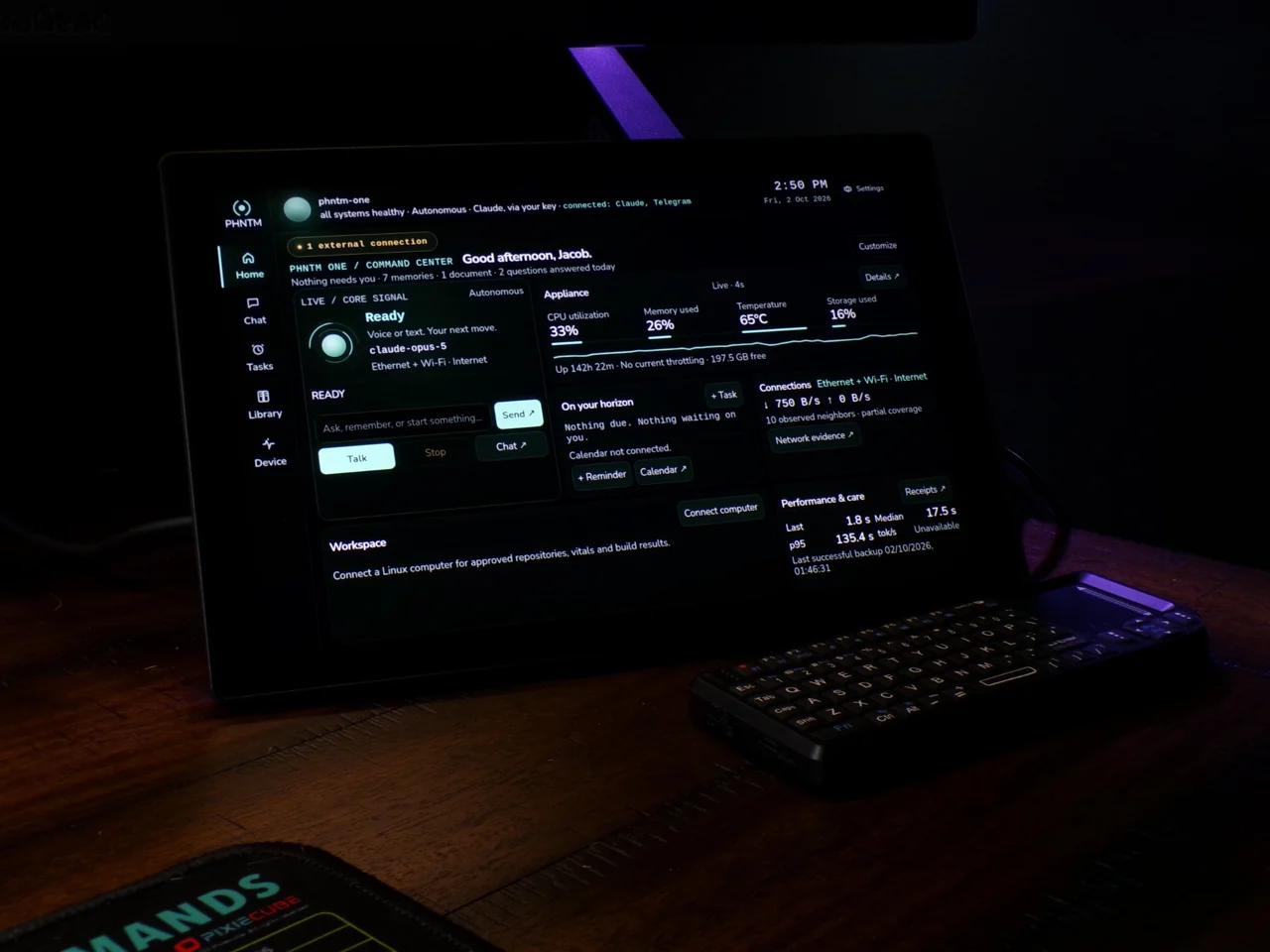 Real PHNTM One touchscreen and included mini keyboard on a desk, showing the Home screen