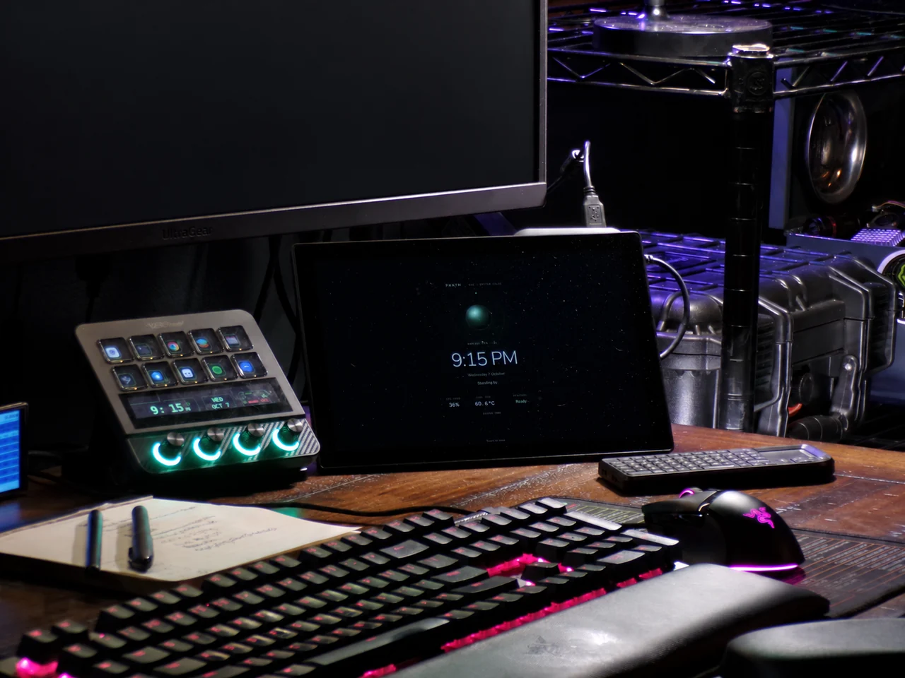 PHNTM One displaying its resting clock and status on Jacob’s desk beside a keyboard and illuminated desk controls; background monitor obscured for privacy