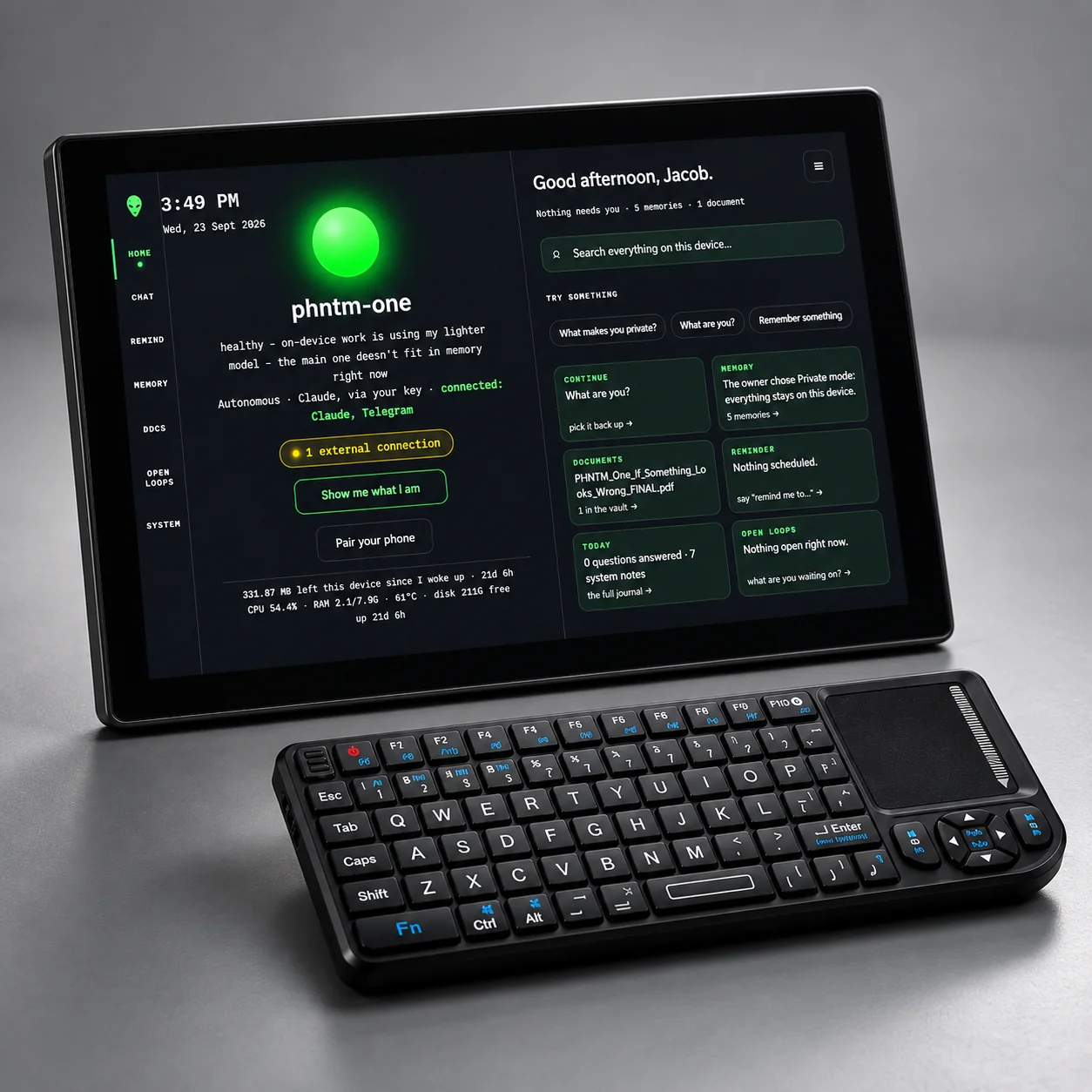 PHNTM One with the mini wireless keyboard that comes in the box, on a grey studio background